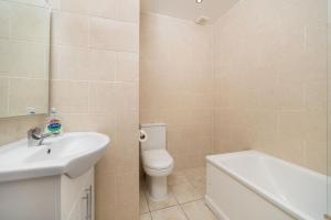 e bagno con lavandino, servizi igienici e vasca. di Single Room G1 (Sandycroft Guest House) a Londra