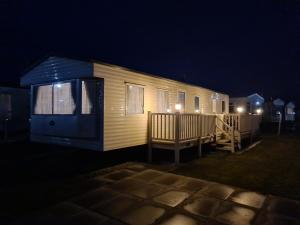 a tiny house with a blue roof at night at Golden Palm - Meadow Lakes in Chapel Saint Leonards