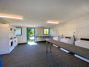 a large kitchen with white appliances and a table at Bundaberg Park Village in Bundaberg