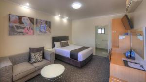 a small room with a bed and a couch at Best Western Ascot Lodge Motor Inn in Goondiwindi