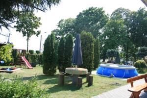 a park with a blue umbrella and a playground at Pokoje U Emilii in Kąty Rybackie