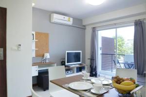 a kitchen with a table with a bowl of fruit on it at The September Salaya in Salaya