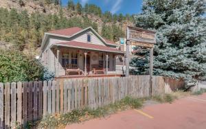 a small house with a fence and a sign at First Deadwood Cottages in Deadwood