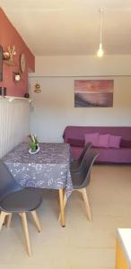 een eettafel met 2 stoelen en een paarse bank bij Niki "s apartment in Pláka