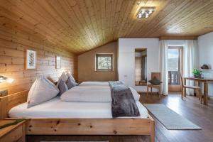 a bedroom with a large bed with a wooden ceiling at Treffhof in Siusi