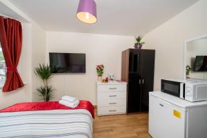 a small bedroom with a bed and a microwave at F4 Modern Double Room (Sandycroft Guest House) in London