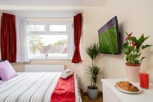 a bedroom with a bed and a plate of food on a table at F4 Modern Double Room (Sandycroft Guest House) in London