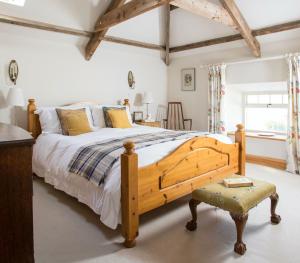 a bedroom with a large bed and a chair at Cragend Grange in Rothbury