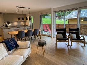a living room with a couch and a table and chairs at Horizon 5 in Schwarzsee