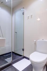 a bathroom with a toilet and a glass shower stall at Park Loft next to Eagle's Bridge in Sofia