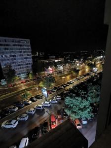 a parking lot full of cars in a city at night at Bulevar Stan na Dan in Novi Sad