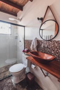 a bathroom with a sink and a toilet and a mirror at Vila Piê in Itacaré