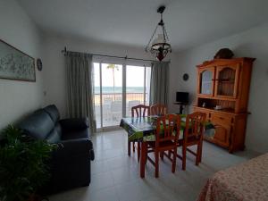sala de estar con mesa, sillas y sofá en Apartamento céntrico en primera linea de playa, en Peñíscola