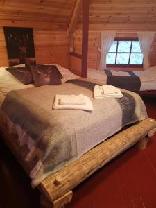 a large bed in a log cabin with towels on it at Vestvatn - Arctic Cabins in Brekke