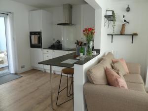 a kitchen with a table and a couch in a room at Two Sails Brixham - Spacious modern family seaside home - parking - wood-burner - dog friendly in Brixham
