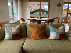 un divano con cuscini in soggiorno di Seehaus / lake view apartment a Iseltwald
