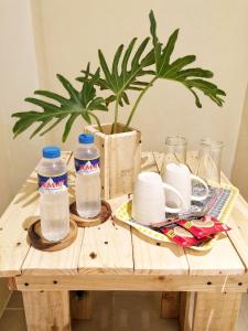 einem Holztisch mit zwei Flaschen Wasser und einer Pflanze in der Unterkunft Matilde’s Sanctuary Bed & Breakfast in Dampol