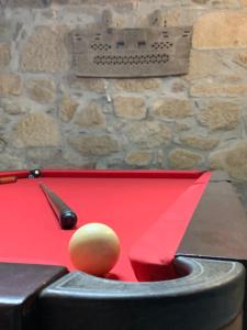 a red pool table with a ball and a cue ball at Quinta de Catapeixe Douro River in Magrelos