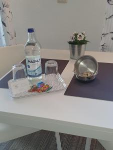 Una botella de agua y dos vasos en una mesa. en Ferienwohnung-Tomme en Wulfen auf Fehmarn