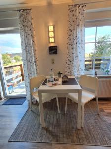 a dining room with a table and chairs and a window at Ferienwohnung-Tomme in Wulfen auf Fehmarn +15 photos