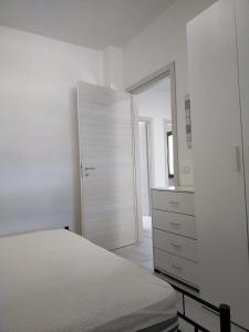 1 dormitorio blanco con 1 cama y vestidor en Oriental Park, en Rossano