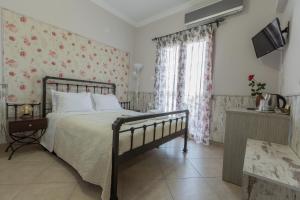 a bedroom with a bed with floral wallpaper at Pegasus Rooms in Korinthos