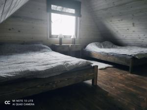 Pod Dębem في Winnica: غرفة نوم بسريرين ونافذة