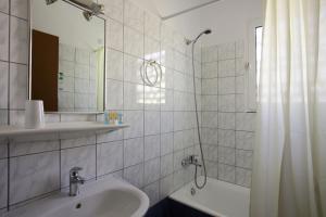 a bathroom with a sink and a mirror and a tub at Evripides Hotel in Athens