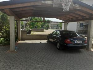 Um carro está estacionado debaixo de um cesto de basquetebol. em Spirit em Medjugorje