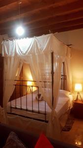 a bedroom with a canopy bed with white curtains at Cosmema House 1 Hot tub and swimming pool villa in Stroumbi