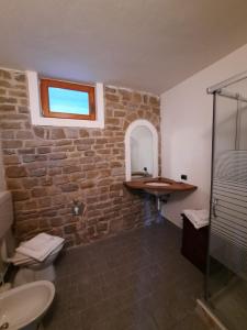 Esino Lario的住宿－Chalet Grigna - Your Mountain Holiday，一间带水槽和石墙的浴室