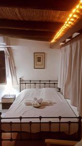 a bedroom with a bed with white sheets at Cosmema house 2 Studio with great mountain view in Stroumbi