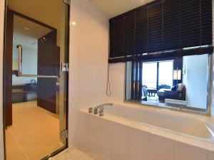 baño con bañera y ventana en Haimurubushi, en Kohama