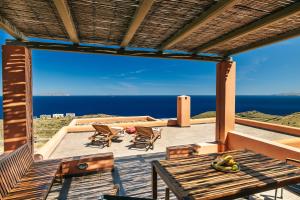 a view from the deck of a house with a table and chairs at Front Row Seat to the Aegean by Neuvel in Ioulis