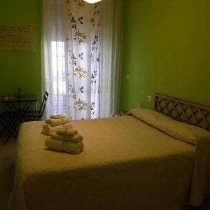 een slaapkamer met 2 bedden, groene muren en een raam bij B&B Da Ninetta in Rome