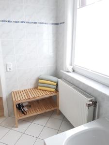 a bathroom with a bench next to a bath tub at Ferienhaus im Bergdorf in Hohegeiß