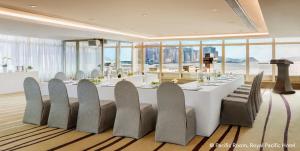 a dining room with a large white table and chairs at The Royal Pacific Hotel & Towers in Hong Kong