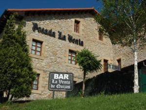 a large stone building with a sign in front of it at La Venta de Quijas in Quijas
