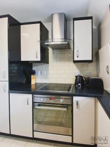 a kitchen with white cabinets and a stove top oven at Manor Apartments in Bournemouth