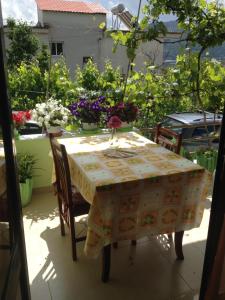 a table and chairs on a balcony with flowers at Guesthouse Aleksander in Berat