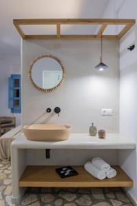 a bathroom with a sink and a mirror at Ihthioessa Boutique Hotel in Astypalaia Town