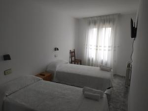 A bed or beds in a room at Hostal Arribes del Duero