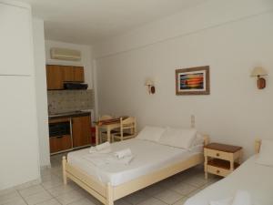 a small bedroom with a bed and a kitchen at Aeolos Hotel Apartments in Gythio