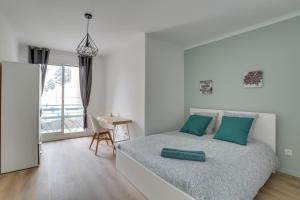 Magnifique T5 (12pers) 129m²-Climatisé-Vieux-Port في مارسيليا: غرفة نوم بيضاء مع سرير مع وسائد خضراء