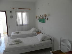 a room with two beds and a window at Aeolos Hotel Apartments in Gythio