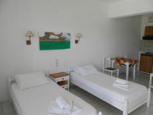 a room with two beds and a table at Aeolos Hotel Apartments in Gythio