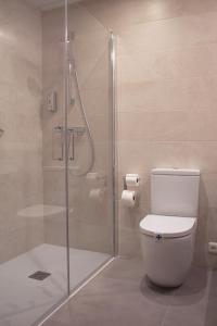 a bathroom with a toilet and a glass shower at Hotel Ezeiza in Donostia-San Sebastián