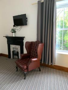 斯旺西的住宿－Rheolau arms，客厅里的真皮座椅,配有电视