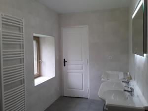 uma casa de banho branca com um lavatório e um espelho em Gîte de Landemeure, 10 couchages, accès PMR em Saint-Germain-du-Crioult