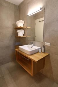W łazience znajduje się umywalka i lustro. w obiekcie Glögglhof w mieście Lana